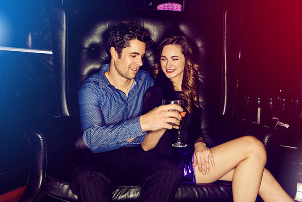 乾杯、素敵な女性。若い男と女がナイトクラブで酒を飲みながら - 写真・画像