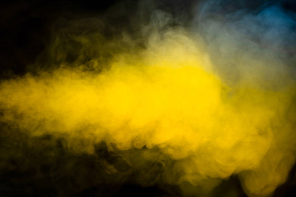 Blue and yellow steam on a black background. Copy space. - Foto, Imagen