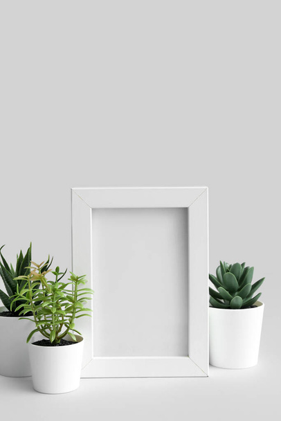 Artificial plants with blank frame on light background - Photo, Image