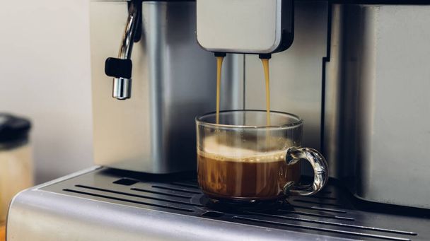 self-service coffee machines offer consistent, quality coffee in hotel, sport club or office. Espresso cappuccino coffee machine on the table. Espresso coffee pouring from espresso machine. Barista  - Foto, afbeelding