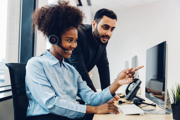 Call center business woman talking on headset. Call center worker accompanied by her team. Customer service executive working at office.	 - Foto, imagen