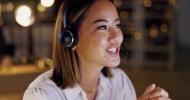 Customer service, woman in office at night and friendly advice at call center for support and networking. Smile, overtime and happy help desk agent or crm consultant, headset and phone call at desk - Felvétel, videó
