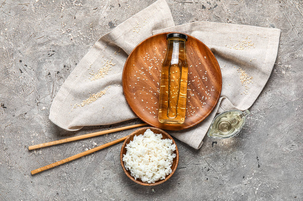 Composição com arroz cozido, garrafa de vinagre e pauzinhos no fundo grunge - Foto, Imagem