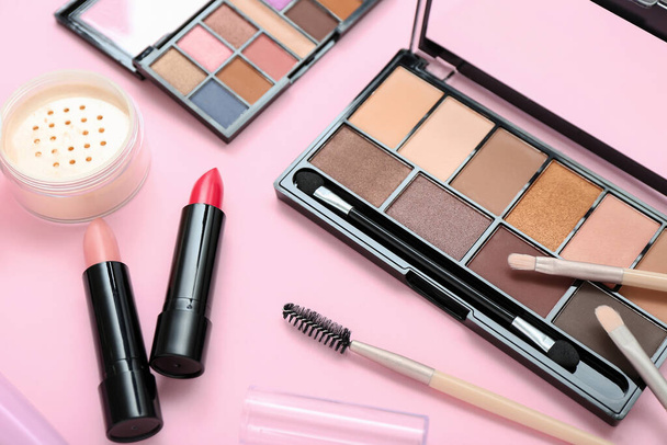 Eyeshadows with brushes and lipsticks on pink background - Photo, Image