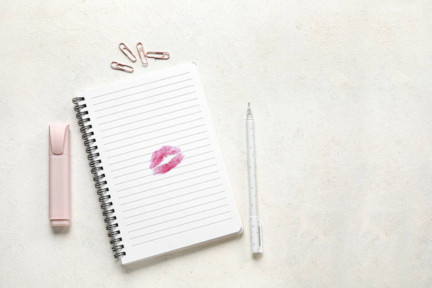Carnet avec marque de baiser rouge à lèvres et papeterie sur fond blanc - Photo, image