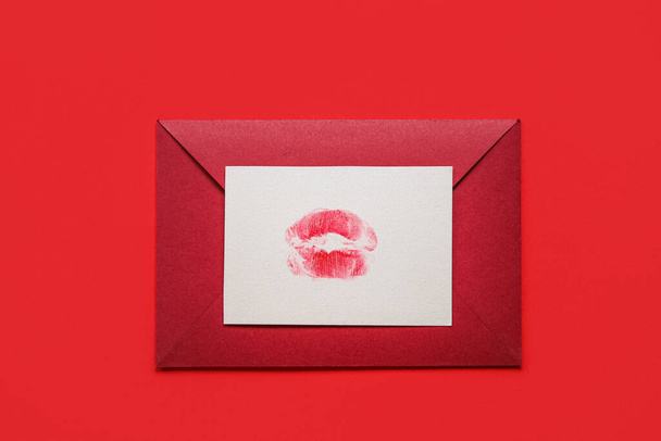 Envelope with lipstick kiss mark on red background - Foto, afbeelding