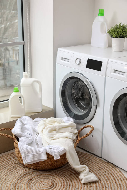 Cesta con ropa sucia cerca de lavadoras en lavadero - Foto, imagen
