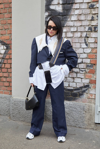 MILAN, ITALY - FEBRUARY 22, 2023: Woman with white shirt, blue trousers and jacket before Fendi fashion show, Milan Fashion Week street style - Foto, Bild