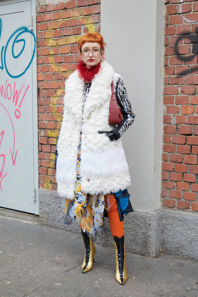 MILAN, ITALY - FEBRUARY 22, 2023: Woman with white fur coat and golden and black boots before Fendi fashion show, Milan Fashion Week street style - Valokuva, kuva