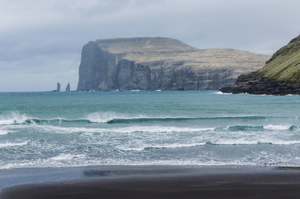 Spiaggia di Tjornuvik, piccolo affascinante villaggio di pescatori a Streymoy, Isole Faroe, Nord Europa, vista su Risin og Kellingin, grandi onde sul mare durante la giornata piovosa - Foto, immagini