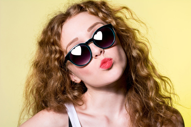 Pretty young beautiful girl in sunglasses makes lips kiss  - Photo, Image