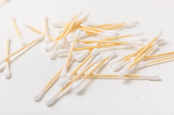 Cotton swabs on a white cement background. Bamboo cotton buds. Means for hygiene of ears. Eco-friendly materials.Hygienic cotton ear buds. - Photo, Image