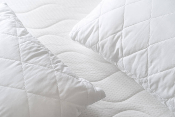 vue de dessus des nouveaux coussins hypoallergéniques sur matelas orthopédique mousse au lit, concept de couchage confort, surface textile coton, gros plan - Photo, image