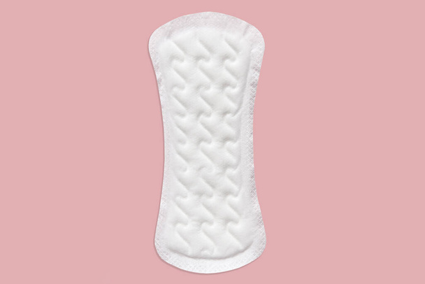 Feminine sanitary pad pattern on pink background. Hygiene care during critical days, caring for women's health. Daily and monthly protection. Copy space. menstrual cycle. - Foto, imagen