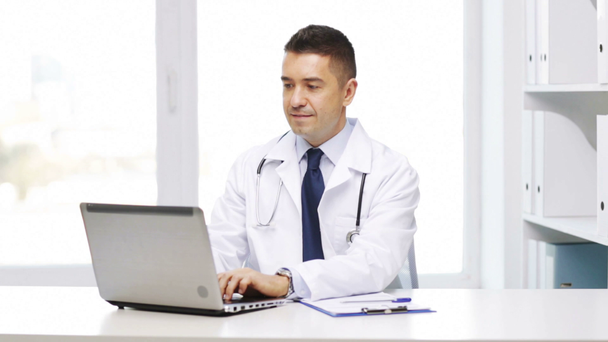 doctor feliz con el ordenador portátil y portapapeles en el hospital
 - Imágenes, Vídeo