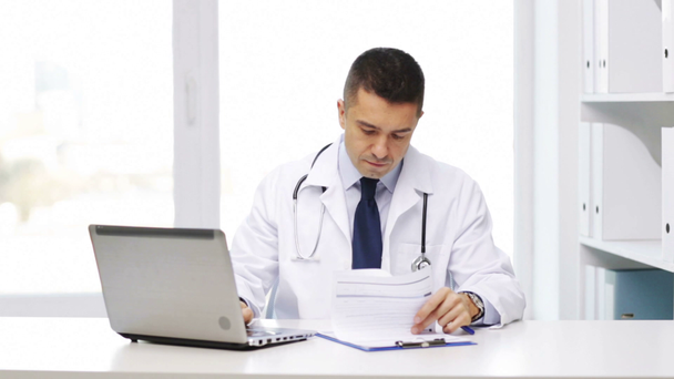 šťastný doktor s notebookem a schránka v nemocnici - Záběry, video