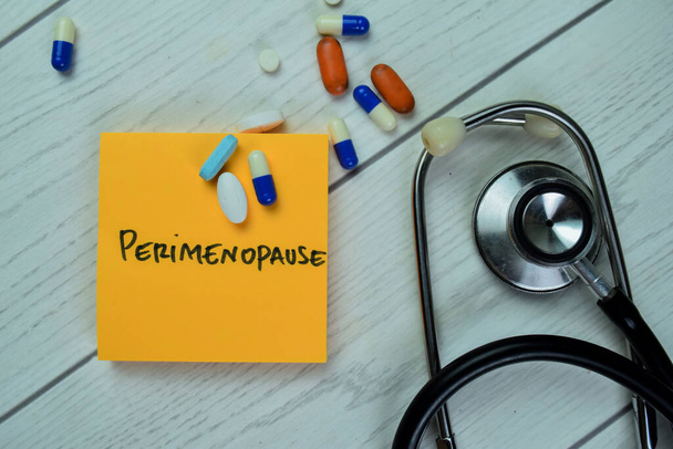 Concept of Perimenopause write on sticky notes with stethoscope isolated on Wooden Table. - Photo, Image