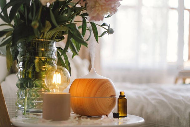 Aromatherapy Concept. Aroma oil diffuser on chair against in the bedroom. Air freshener. Ultrasonic aroma diffuser for home - Valokuva, kuva