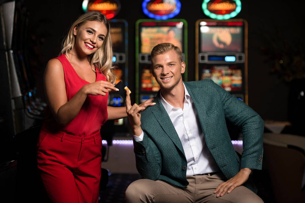 Portrait of a Young Beautiful and Well Dressed Couple Playing in the Casino and Celebrate Holding Vip Card - Zdjęcie, obraz