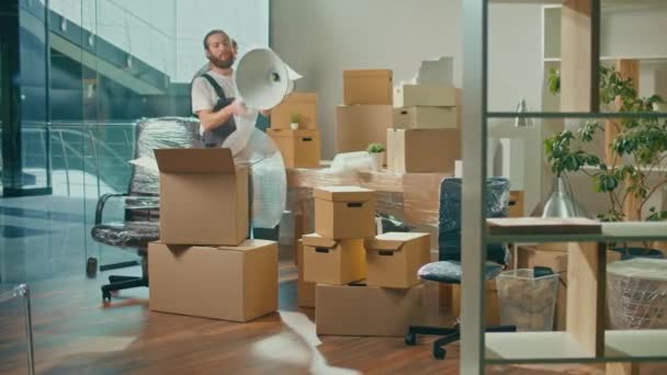 ユニフォーム付き移動会社の労働者慎重に梱包し、箱を運ぶ。従業員のチームはお客様の移転を支援します。運送・包装事業職業紹介会社. - 映像、動画