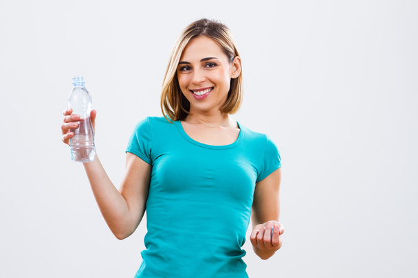 Woman is holding bottle of water - Foto, Imagen