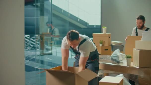 ユニフォーム付き移動会社の労働者慎重に梱包し、箱を運ぶ。運送・梱包事業職業紹介会社。長い旅の準備、物事の輸送 - 映像、動画