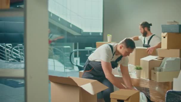 ユニフォーム付き移動会社の労働者慎重に梱包し、箱を運ぶ。運送・梱包事業職業紹介会社。長い旅の準備、物事の輸送 - 映像、動画