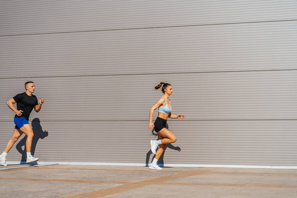 М'язова спортивна пара тренується разом на вулиці в сонячний день. Вони бігають
 - Фото, зображення