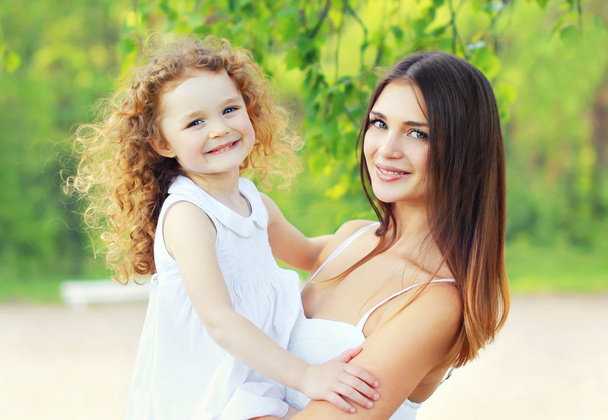 Portrait lovely young mother and cute daughter in sunny summer d - Foto, Imagen