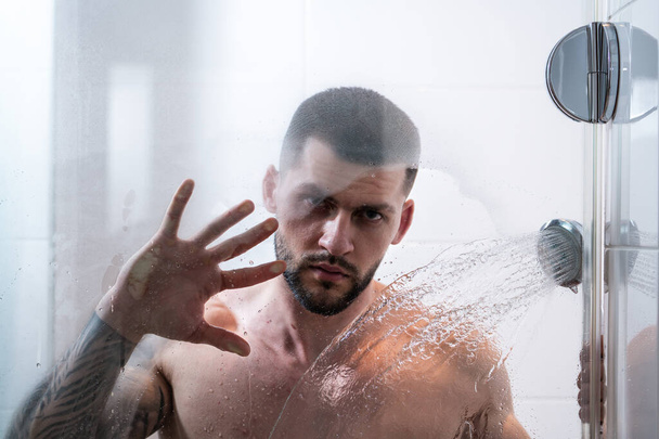 shower. Guy taking shower in bathroom. Relaxing time. Fresh shower. Good looking man is under water drops - Фото, зображення