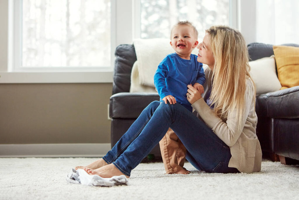 I know just how to cheer him up. a happy young mother playing with her baby boy at home - Фото, изображение