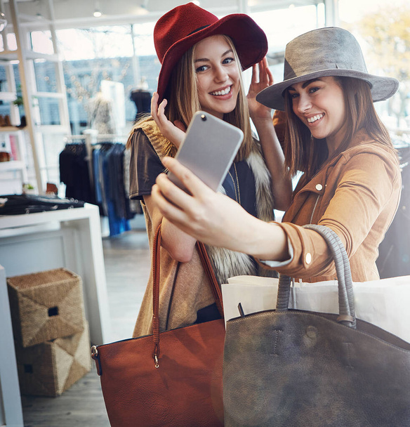 This is the one. two young girlfriends snapping selfies while out on a shopping spree - 写真・画像
