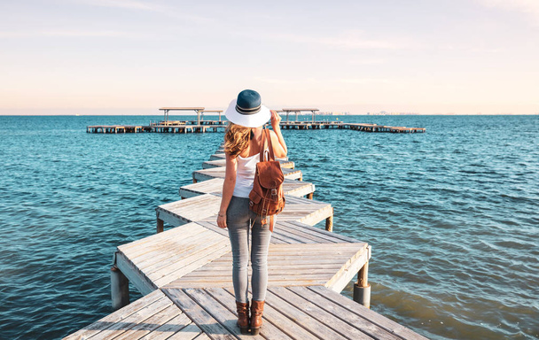 Woman on wooden pier with hat and bag- Spain, Mar menor,Murcia - Fotografie, Obrázek