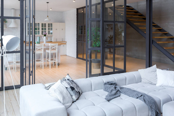 trendy modern design two-level apartment with large high windows. The stylish living room and kitchen in bright colors are undressed by a glass partition. bedroom on the second floor. - Φωτογραφία, εικόνα
