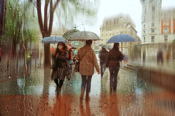 people with an umbrella in rainy days in winter season, bilbao, basque country, spain  - Zdjęcie, obraz