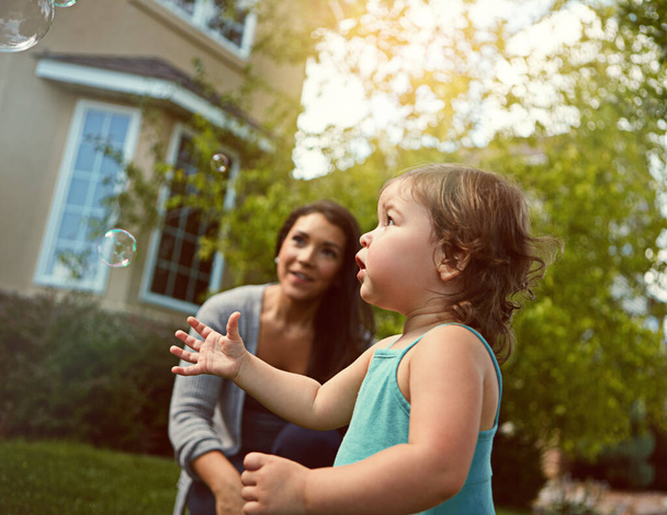 Gotta catch them all before they fly away. a mother and her adorable little daughter playing with bubbles outside - Photo, Image