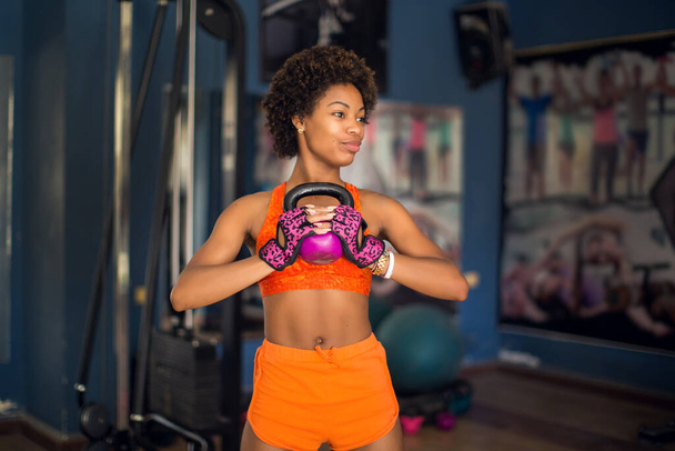 Mulher fitness com kettlebell fazendo exercício em um ginásio. Conceito de saúde e estilo de vida - Foto, Imagem