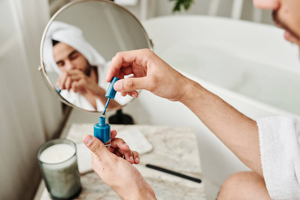 Крупним планом молодий чоловік відкриває синій лак і фарбує нігті після процедури ванни
 - Фото, зображення