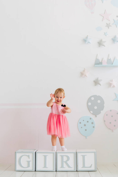 concept of children's emotions. Portrait of lovely toddler little baby child with pink dress - Foto, Imagem