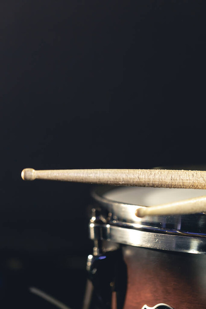 Close-up, snare drum e baquetas em um fundo escuro, conceito de concerto, instrumento de percussão close-up. - Foto, Imagem