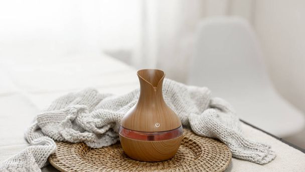 Aroma oil diffuser lamp on a blurred background in the interior of the room, copy space. - Photo, Image