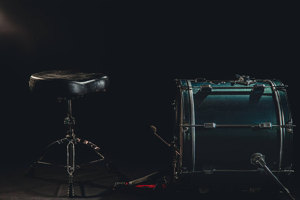 Basso tamburo e sedia su sfondo nero, posto batteristi, il concetto di suonare uno strumento a percussione. - Foto, immagini
