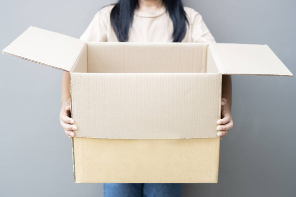 Vrouwenhanden openen bruine kartonnen doos. Concept van het gebruik van kringlooppapier doos - nul afval. Binnenkant van een doos met vrije ruimte voor uw tekst. - Foto, afbeelding