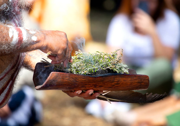 Ihmisen kädet pitävät puinen ruokalaji Australian kasvi oksat, savu rituaali riitti alkuperäiskansojen yhteisön tapahtuma Australiassa - Valokuva, kuva
