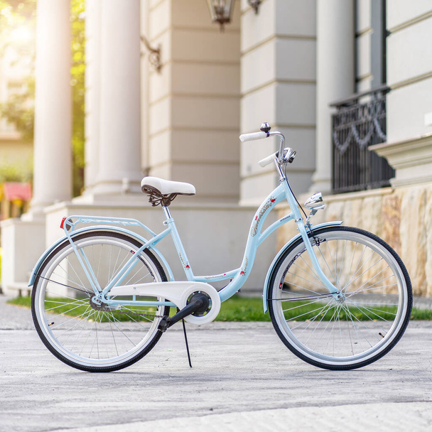 Widok z boku nowoczesnego miejskiego roweru miejskiego lub roweru do ulicy. Miejski rower zaparkowany na trawniku. Miejski rower stojący pionowo na trawie, statyczny, bez ludzi. - Zdjęcie, obraz