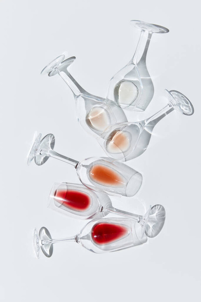 Art of traditional wine taste. Glasses with drops of different red, white and rose wine against white background. Vertical layout. Concept of taste, alcohol, wine degustation, winemaking. Flat lay - Foto, Imagem