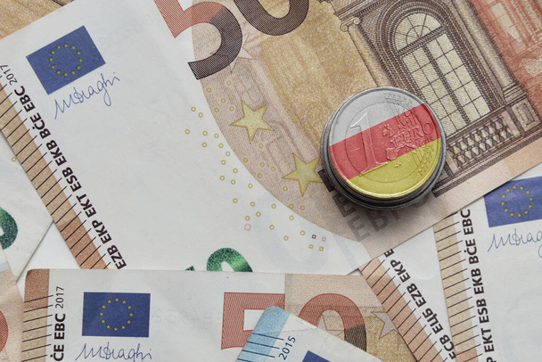 Moneda en euros con bandera nacional colorida de Osetia del Sur sobre el fondo de los billetes en euros - Foto, imagen