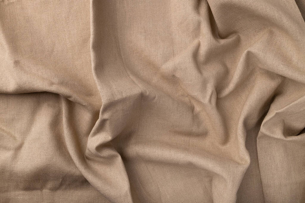 Natural linen fabric texture. Flaxen textile background, top view. Rough crumpled burlap - Foto, Bild