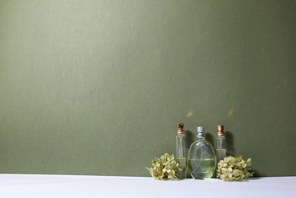 perfume with a sprig of hydrangea on a white and green background - 写真・画像