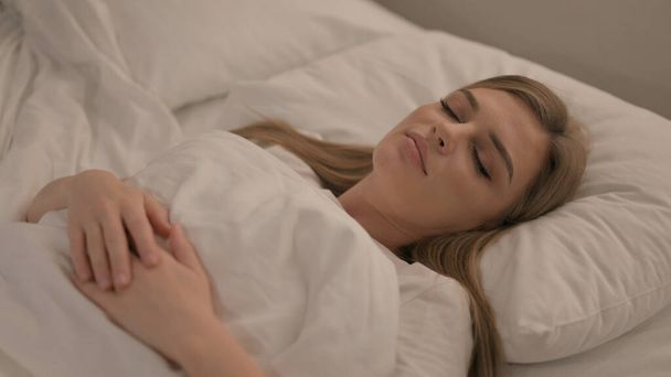 Fatigué jeune femme dormir dans le lit à la maison - Photo, image